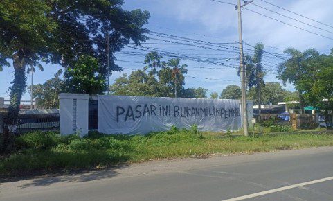 Sepanduk yang terbentang di pinggiran jalan besar yang bertuliskan pasar ini terpasang di depan Kantor Kecamatan Kencong, Kabupaten Jember, Jawa Timur. Lokasinya yang strategis dan ukurannya yang cukup besar membuat spanduk ini langsung menyita perhatian warga dan para pengguna jalan yang melintas bukan milik Pemkab. Menjadi perhatian bagi pengguna jalan
