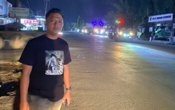 Ketua KNPI Pangkalan Kuras M. Dony Ardiansyah berdiri di Jalan Datuk Laksamana Sorek Satu meninjau kerusakan jalan umum