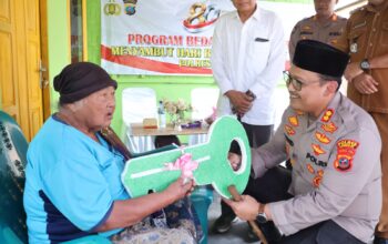 Momen Ibu Ginah menyematkan sarung ke leher Kapolres Langkat AKBP David Triyo Prasojo saat penyerahan bedah rumah