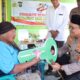 Momen Ibu Ginah menyematkan sarung ke leher Kapolres Langkat AKBP David Triyo Prasojo saat penyerahan bedah rumah