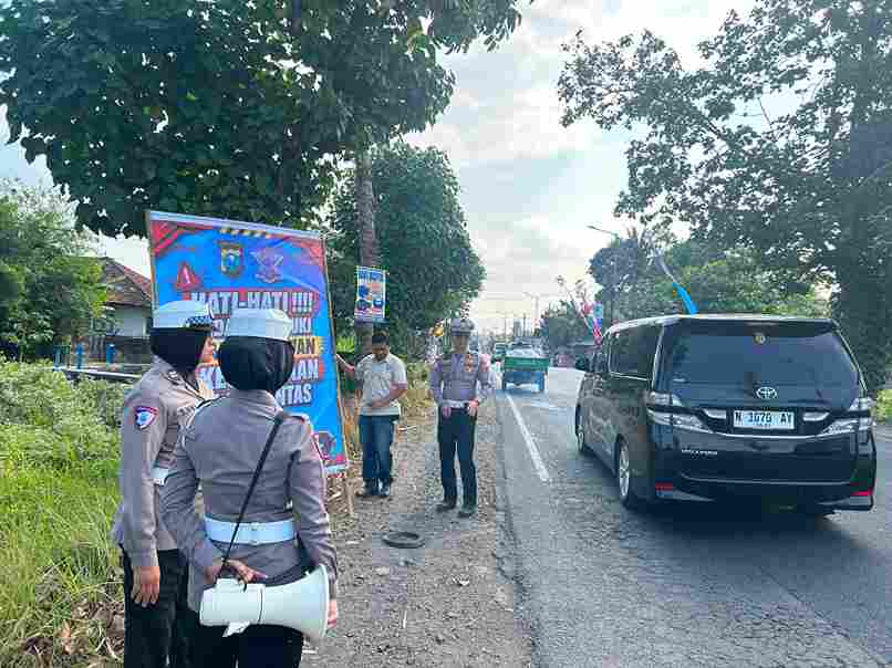 Personel Satlantas Polres Jember pasang banner imbauan di titik blackspot Desa Langkap Bangsalsari.