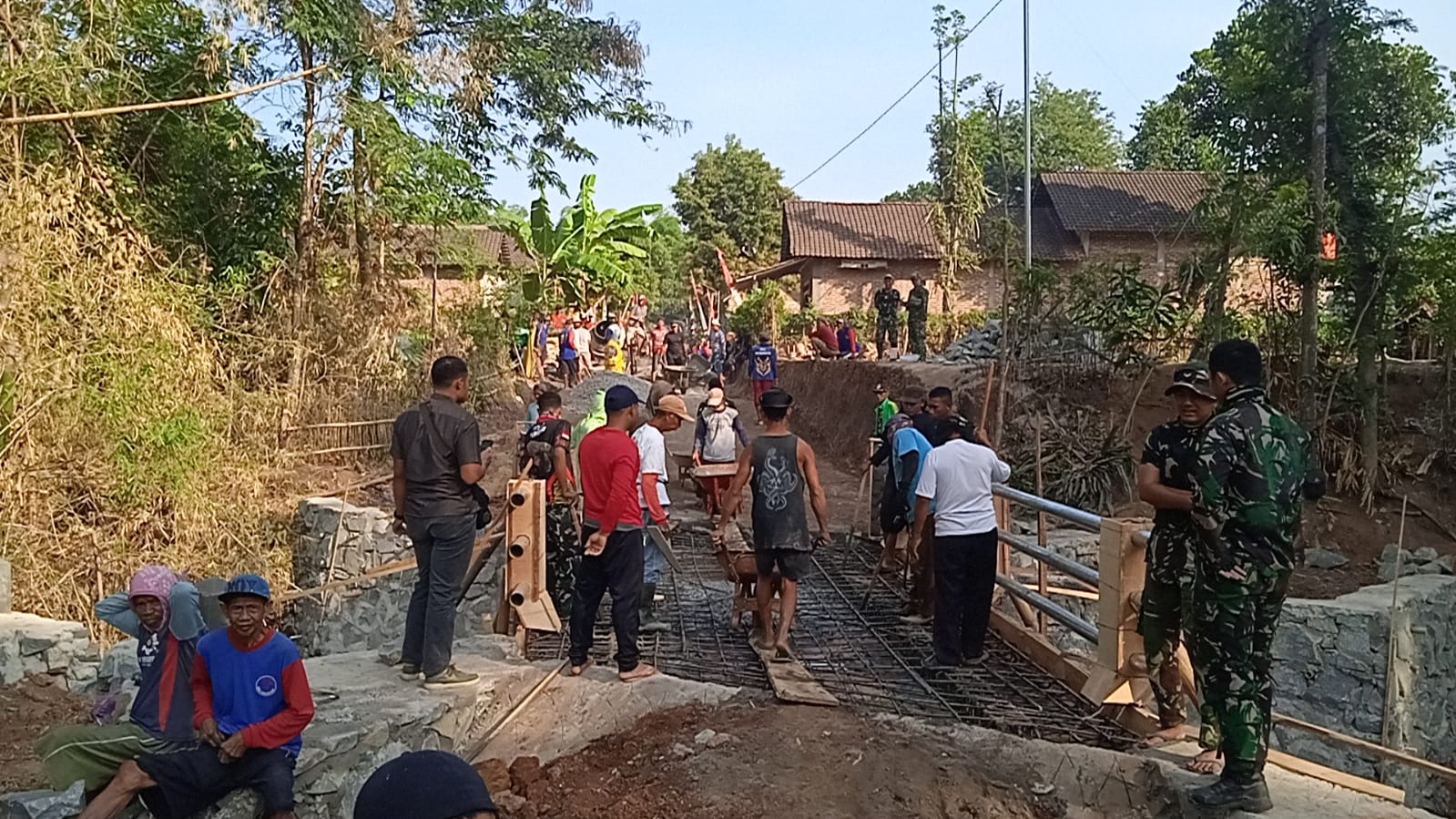 Personel Satgas TMMD Ke-129 Kodim 0802/Ponorogo bersama warga bangun jembatan di Bulu Lor Ponorogo.