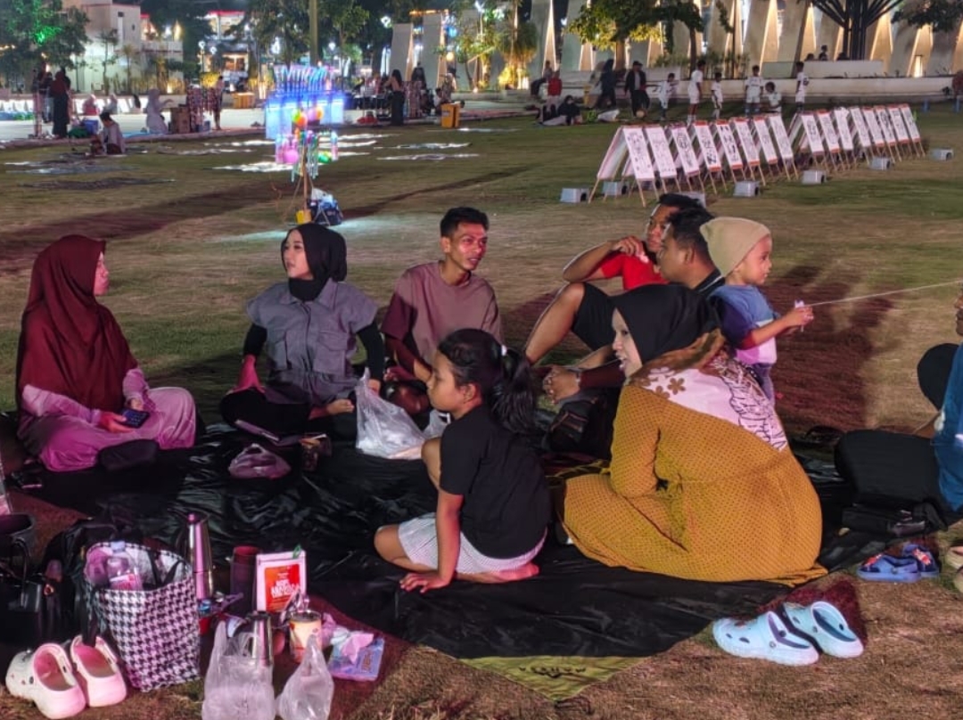 Warga dan keluarga manfaatkan Alun-Alun Jember yang tertata rapi untuk tempat berkumpul dan arisan.