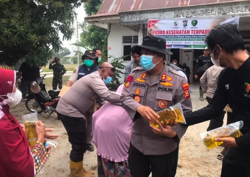 Kapolres Pelalawan AKBP Jhon Louis Letedara turun langsung memberikan masker dan sembako kepada warga di Kerumutan.