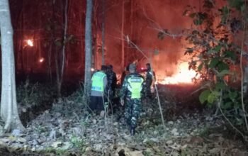 Babinsa Kodim Ponorogo bersama warga memadamkan kebakaran pekarangan.