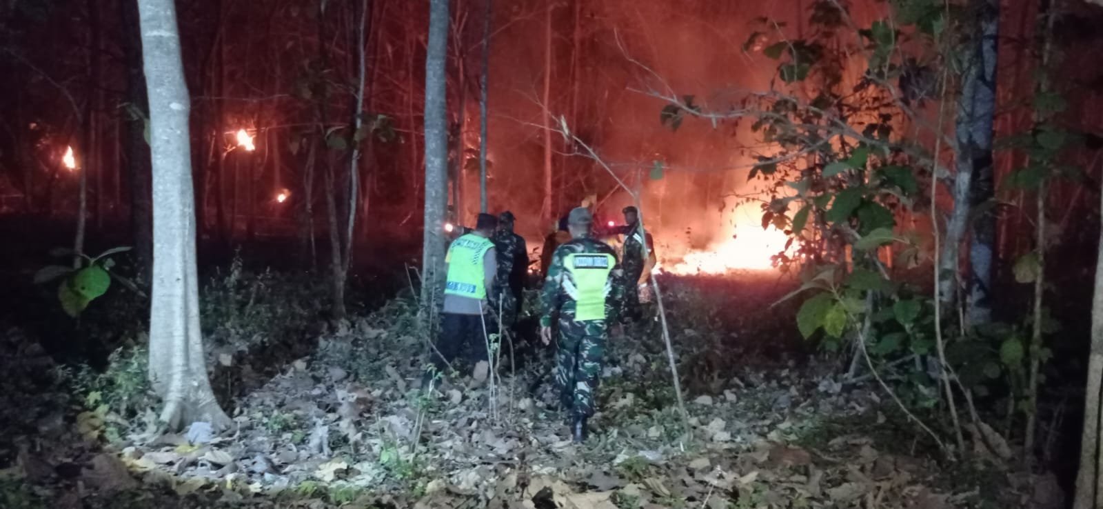 Babinsa Kodim Ponorogo bersama warga memadamkan kebakaran pekarangan.