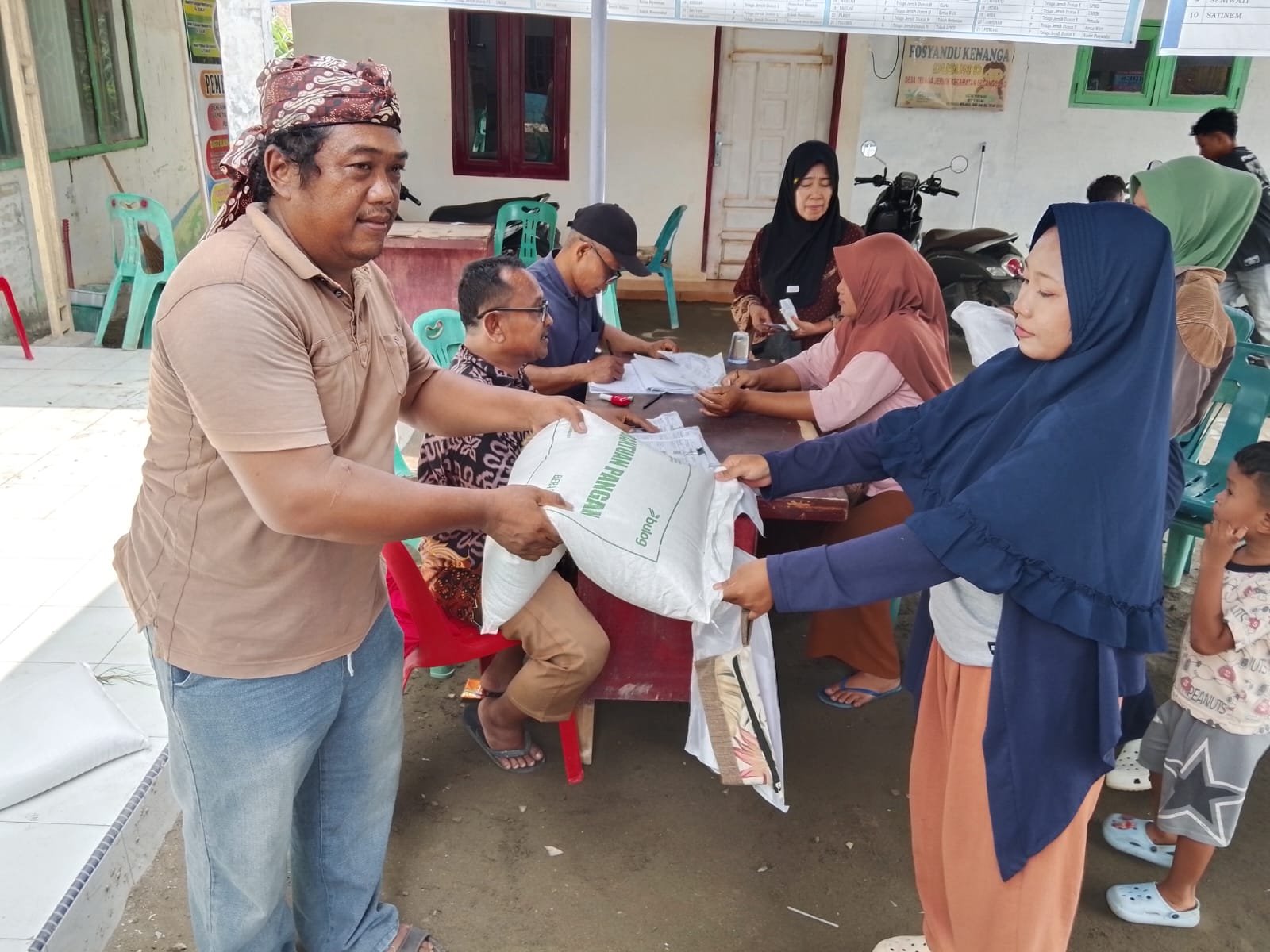 Penyaluran bantuan beras Bulog kepada warga di Kantor Desa Telaga Jernih, Langkat.