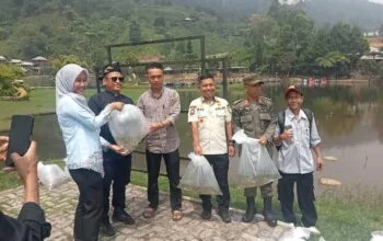 Petugas Dinas Perikanan dan warga saat melakukan penebaran benih ikan nila di perairan Rawa Gede, Sukamakmur.