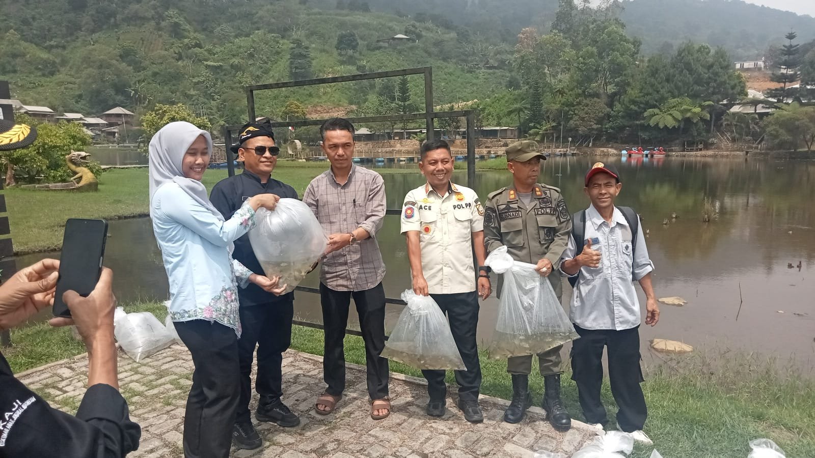 Petugas Dinas Perikanan dan warga saat melakukan penebaran benih ikan nila di perairan Rawa Gede, Sukamakmur.