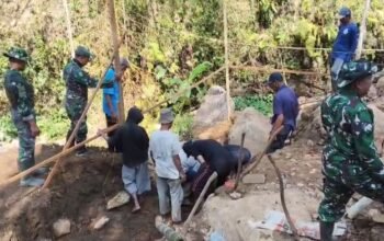 Anggota TNI bersama warga gotong royong membangun Jembatan Perintis Garuda di Ponorogo.