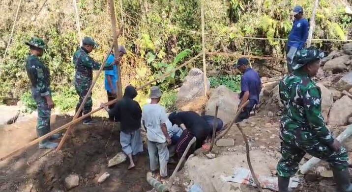 Anggota TNI bersama warga gotong royong membangun Jembatan Perintis Garuda di Ponorogo.
