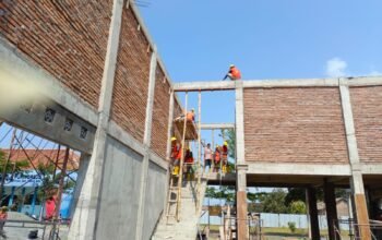 Pekerja proyek revitalisasi SMKN 4 Purworejo tampak sudah menggunakan helm keselamatan dan APD lengkap saat beraktivitas.