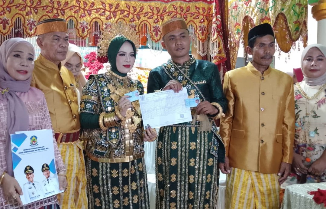 Perwakilan Dinas Dukcapil Jeneponto menyerahkan KK dan KTP baru kepada pasangan pengantin di Turatea.