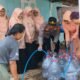 Petugas Polsek Pitu bersama pengurus DWP mengisikan air bersih ke wadah penampungan milik warga di Desa Cantel Pitu Ngawi.